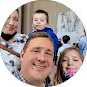 Smiling man, woman, and two children posing closely for a group photo indoors.
